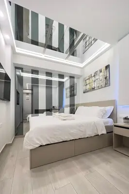 a bedroom with a large white bed with a skylight at Stylish Living - Iro in Athens