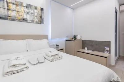 a bedroom with a white bed with towels on it at Stylish Living - Iro in Athens