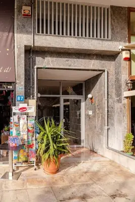 a building entrance with a potted plant in front of it at Elegant 2BD Evelpidon Apartment in Athens