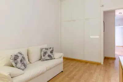 a white living room with a white couch and wooden floors at Elegant 2BD Evelpidon Apartment in Athens
