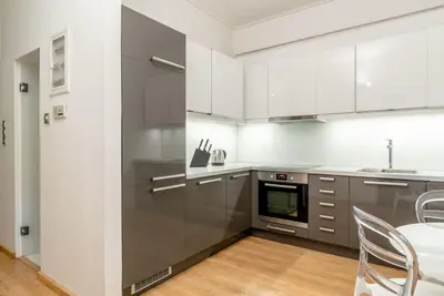 a kitchen with white cabinets and a table and chairs at Elegant 2BD Evelpidon Apartment in Athens