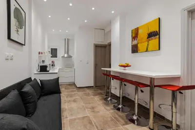 a living room with a couch and a kitchen at Bijou apartment in Glyfada center in Athens