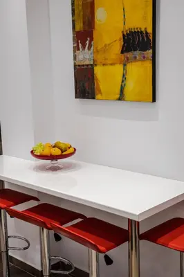 a white table with a bowl of fruit on it at Bijou apartment in Glyfada center in Athens