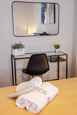 a mirror over a desk with a chair and a towel at Bijou apartment in Glyfada center in Athens