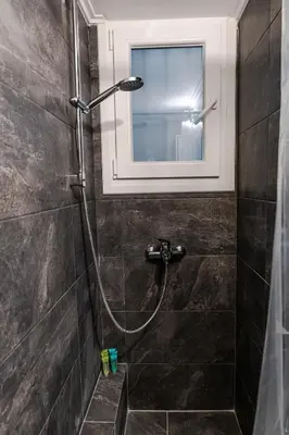 a shower in a bathroom with a window at Bijou apartment in Glyfada center in Athens