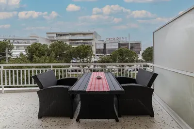 a table and chairs on a balcony with a view at Bijou apartment in Glyfada center in Athens