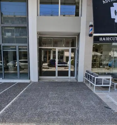 an empty building with doors and a bench in front at Bijou apartment in Glyfada center in Athens