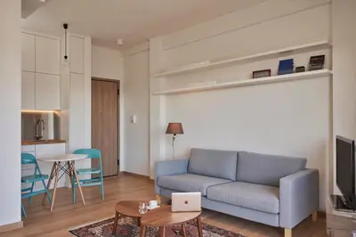 a living room with a blue couch and a table at Acropolis view penthouse in Athens