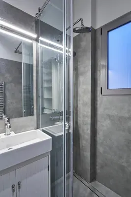 a bathroom with a shower and a sink and a mirror at Acropolis view penthouse in Athens