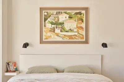 a painting above a bed in a bedroom at Acropolis view penthouse in Athens