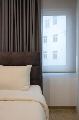 a bedroom with a bed and a large window at Dema Luxury Suites - Lekka E3 in Athens