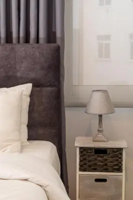 a bed and a nightstand with a lamp on it at Dema Luxury Suites - Lekka E3 in Athens