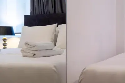 two towels stacked on a bed in a room at Dema Luxury Suites - Lekka E3 in Athens