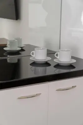 three cups and saucers on a kitchen counter at Dema Luxury Suites - Lekka E3 in Athens