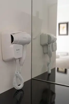 a room with a hair dryer and a phone at Dema Luxury Suites - Lekka E3 in Athens
