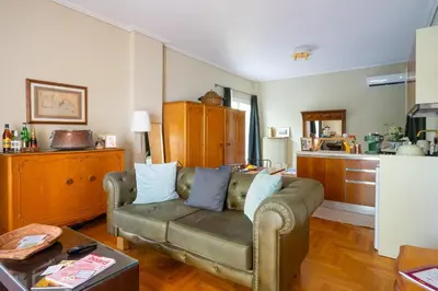 a living room with a couch and a kitchen at Magnificent Bnb Athens Voula in Athens
