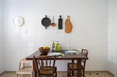 a kitchen with a wooden table with chairs at Magnificent Bnb Athens Voula in Athens