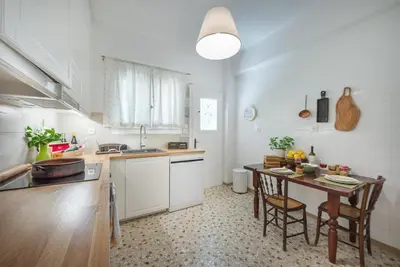 a kitchen with a table and some chairs in it at Magnificent Bnb Athens Voula in Athens