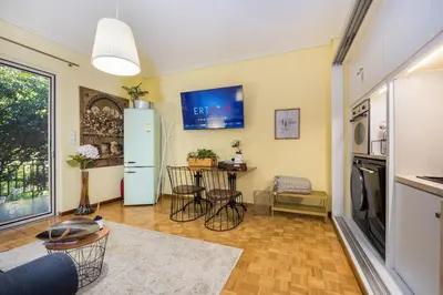 a living room with a refrigerator and a table at Magnificent Bnb Athens Voula in Athens