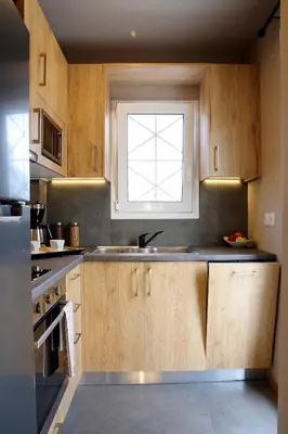 a kitchen with wooden cabinets and a window at Absolute Athens XIV View in Athens