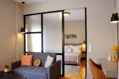 a bedroom with a bed and a couch and a mirror at Absolute Athens XIV View in Athens