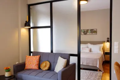 a bedroom with a bed and a couch with pillows at Absolute Athens XIV View in Athens