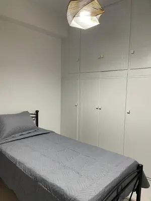 a bedroom with a bed and white cabinets at Athens Studio in Athens
