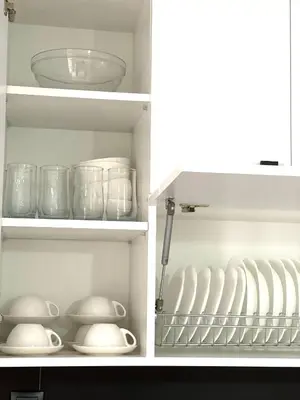 a white kitchen cabinet with dishes and bowls in it at Athens Studio in Athens