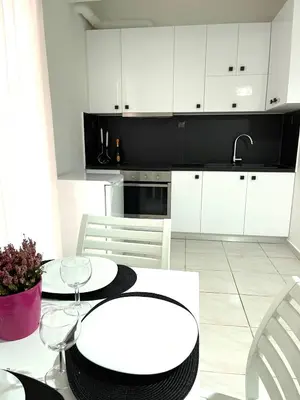 a kitchen with white cabinets and a white table and chairs at Athens Studio in Athens