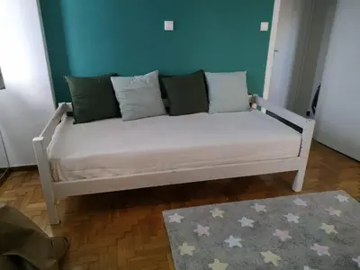 a white couch with pillows on it in a room at Fully renovated, family-friendly apartment, next to a huge green park, in Athens center in Athens