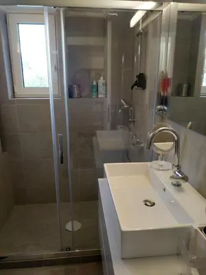 a bathroom with a white sink and a shower at Fully renovated, family-friendly apartment, next to a huge green park, in Athens center in Athens