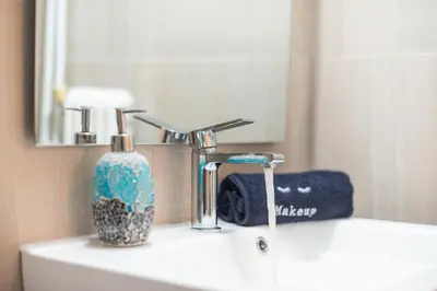 a bathroom sink with a toothbrush holder and a mirror at Easy Living Suite by Cloudkeys in Athens