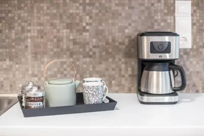 a coffee maker and two mugs on a kitchen counter at Easy Living Suite by Cloudkeys in Athens