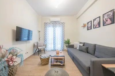 a living room with a couch and a tv at Easy Living Suite by Cloudkeys in Athens