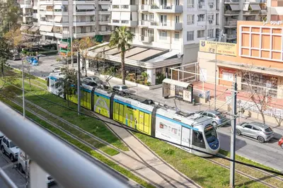 a train on the tracks in a city at The Skyward Flats in Néa Smírni