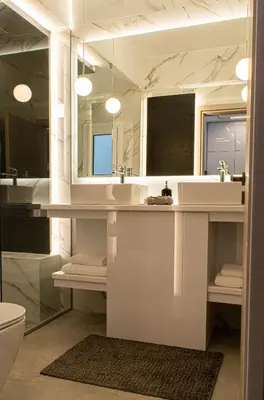 a bathroom with a sink and a toilet and a mirror at Aether Home - Modern & Luxe Stay with 65 TV by TT in Athens