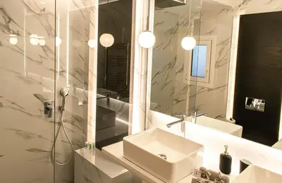 a white bathroom with a sink and a mirror at Aether Home - Modern & Luxe Stay with 65 TV by TT in Athens