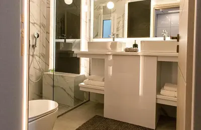 a bathroom with two sinks and a toilet at Aether Home - Modern & Luxe Stay with 65 TV by TT in Athens