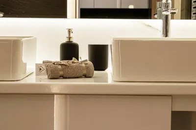 a bathroom counter with a sink and a soap dispenser at Aether Home - Modern & Luxe Stay with 65 TV by TT in Athens
