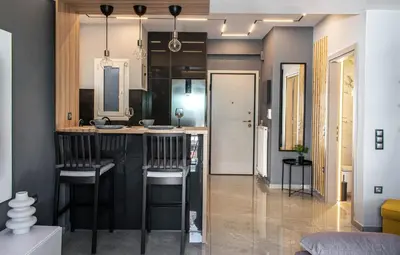 a kitchen with a black island with bar stools at Aether Home - Modern & Luxe Stay with 65 TV by TT in Athens