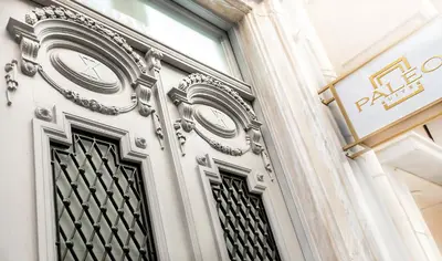 a door with a clock on the side of a building at Paleo Suites in Athens