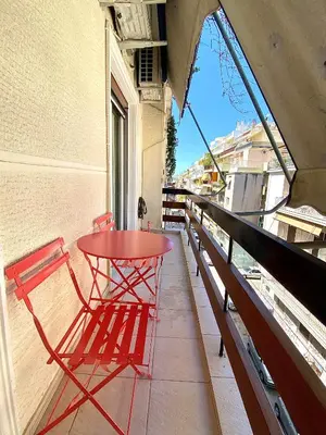 a red table and chairs on a balcony at Ultimate Downtown Athens Escape in Athens