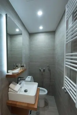 a bathroom with a sink and a toilet and a mirror at Athenais Luxury Apartment in Athens