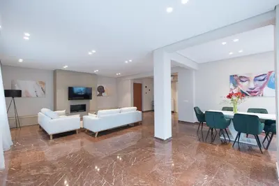 a living room with a couch and a table and chairs at Athenais Luxury Apartment in Athens
