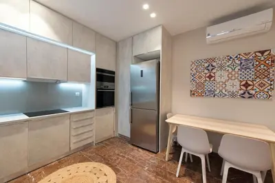 a kitchen with a table and a refrigerator at Athenais Luxury Apartment in Athens