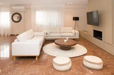 a living room with a white couch and a table at Athenais Luxury Apartment in Athens