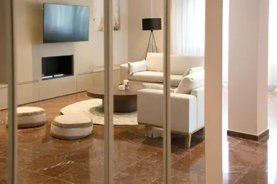 a living room with a couch and a chair and a television at Athenais Luxury Apartment in Athens