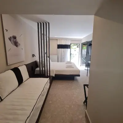 a living room with a couch and a bed at Cityzoe Athens Suites in Athens