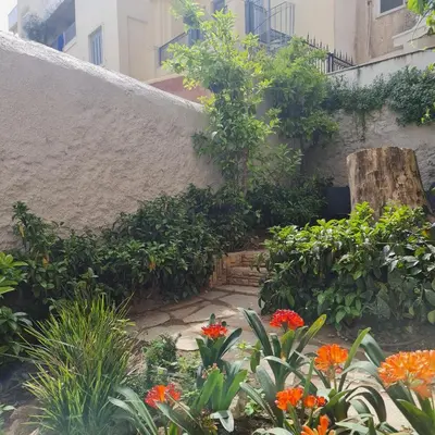 a garden with flowers in front of a building at Cityzoe Athens Suites in Athens
