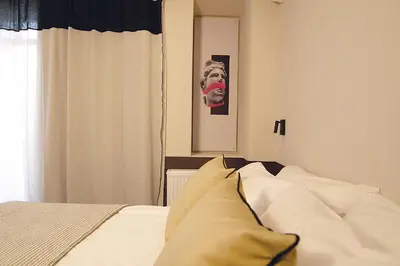 a bedroom with a bed with a mask on the wall at Cityzoe Athens Suites in Athens